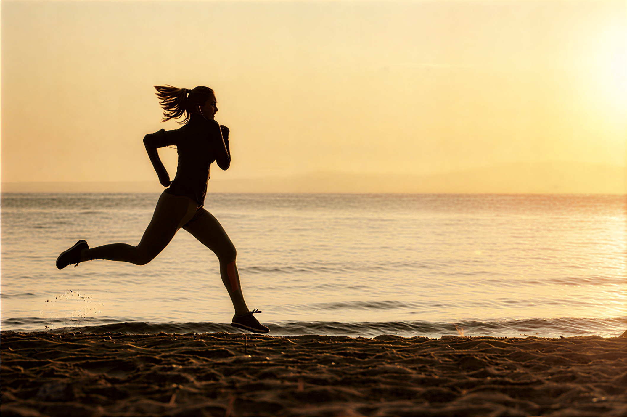 Runner on beach at sunset